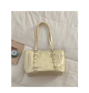 Detailed view of the light yellow minimalist tote bag showing straps and metal rings