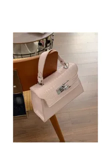 Detailaufnahme der rosa Kroko-Muster Kelly Handtasche mit silbernem Metall-Verschluss.