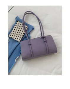 Detail shot of minimalist purple shoulder bag with slim straps and cute decorative accents.