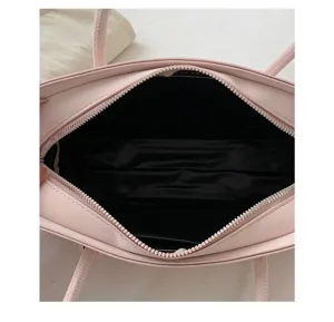 Detail view of pink minimalist women underarm handbag interior structure with zip closure.