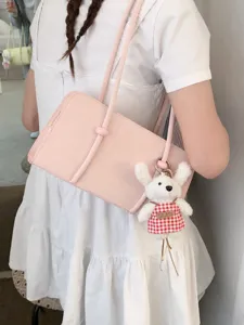 Pink underarm shoulder bag for women, minimalist small square handbag with cute plush keychain.