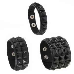 Detailed close-up of black punk leather bracelets featuring square metal studs and snap closures.
