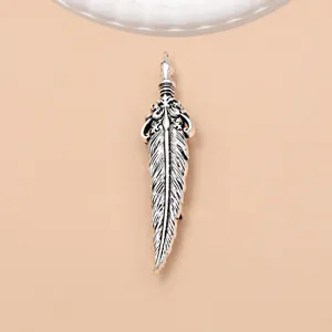 Close up of retro silver feather brooch pin, detailed antique metal texture design.