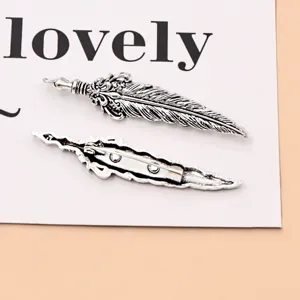 Detail view of vintage silver feather brooch pin, showcasing intricate texture and secure clasp.