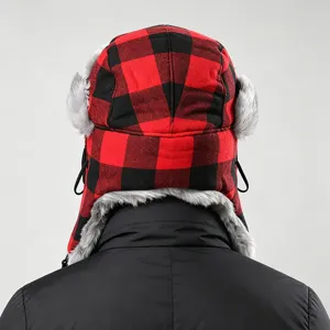 Details of the red and black plaid trapper hat, showing cozy faux fur earflaps and thermal design.