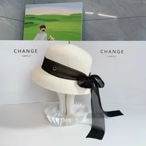 Elegante cappello da sole bianco in stile Hepburn con nastro nero, copricapo di paglia chic.