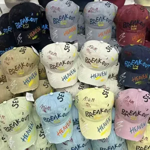 Close-up detail of street style graffiti baseball caps with colorful letters and crown prints.