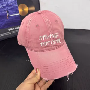 Detalle de gorra de béisbol rosa desgastada, gorra bordada casual para mujeres.