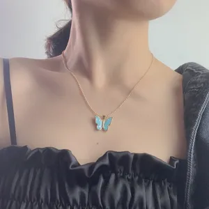 Detail close-up shot of the elegant blue shell butterfly pendant necklace worn on neck.