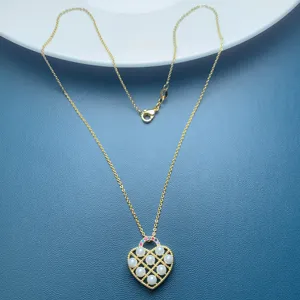 Elegant gold heart pendant necklace with pearl lattice design and sparkling stones for women.