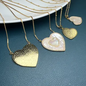 Elegante collana con ciondolo a cuore dorato con madreperla e dettagli di catena.