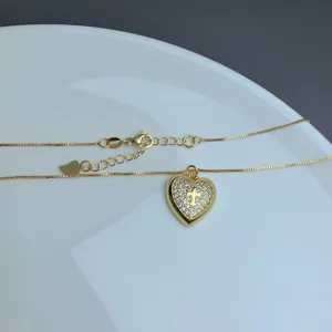 Gold micro-pave rhinestone heart necklace detail, delicate cross pendant clavicle chain accessory.