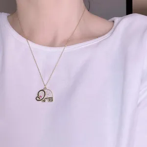 Chic micro-pave rhinestone elephant pendant necklace detail shot, delicate gold chain jewelry.