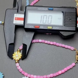 Pink shell beaded bracelet detail closeup showing 10mm flower charm size measurement view.