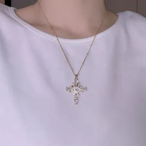 Dettaglio collana con pendente croce malocchio in zircone, gioielli retro da donna.