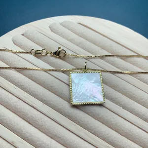 Minimalist gold box chain necklace featuring a square white mother-of-pearl pendant.
