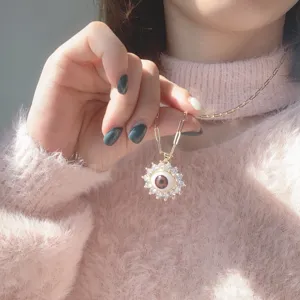 Detailed close-up of the evil eye necklace featuring sparkling zircon and realistic brown eye pendant.