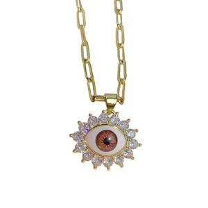 Gold evil eye pendant necklace with sparkling cubic zirconia stones and paperclip chain.