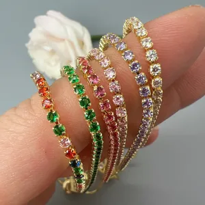 Close-up detail of multi-color cubic zirconia tennis bracelets stacked on fingers, fashion jewelry.