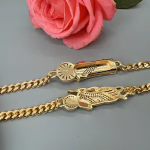Detail shot of gold Cuban link bracelet featuring unique sneaker charm and sparkling cubic zirconia.