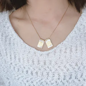 Vue détaillée d'un collier ras de cou vintage à double pendentif en coquillage et chaîne dorée.