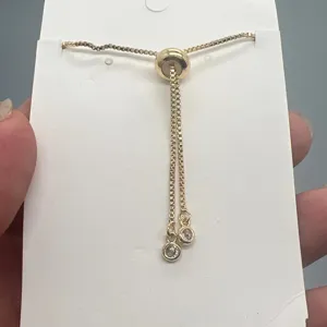 Detail van verstelbare vergulde schuifketting armband met sprankelende zirkonia bedels.