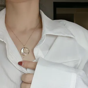 Collier en or avec pendentif lune et étoile en nacre, chaîne claviculaire délicate.