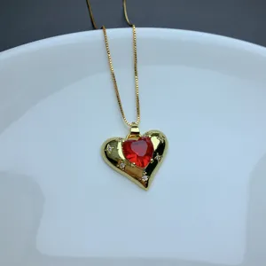 Gold chain necklace featuring a red heart pendant with micro-set rhinestones, detailed view.