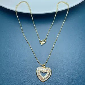 Exquisite heart pendant necklace detailed view, gold tone chain with sparkling zircon stones.