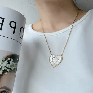 Collana con doppio ciondolo a cuore dorato in madreperla bianca naturale e catena sottile.
