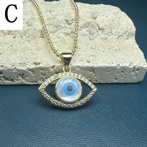 Close-up detail of the evil eye pendant necklace with sparkling stone accents and gold finish.