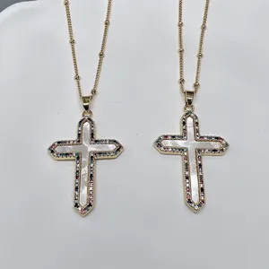 Close-up of golden cross necklaces featuring white mother-of-pearl and colorful zirconia stones.