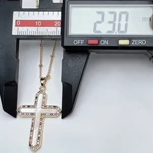 Detailed shot of gold cross necklace pendant with white shell and colorful zircon stones.