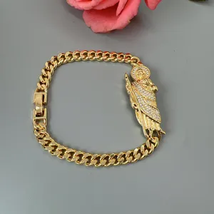 Gold cuban link bracelet featuring a rhinestone paved religious figure pendant for women.