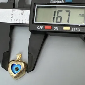 Ciondolo cuore occhio malvagio dorato dettaglio con dimensioni precise calibro digitale.