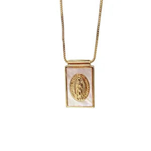 Collier chaîne dorée avec pendentif rectangulaire en nacre et médaille religieuse gravée.