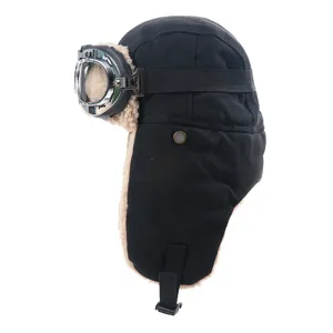 Gedetailleerde opname van de zwarte winter pilotenmuts met skibril en warme fleece oorkleppen.