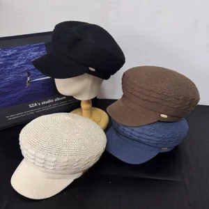 Detailed shot of retro knitted newsboy cap, featuring breathable mesh and metal side tag.