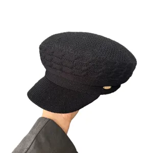 Vintage black knit newsboy cap with metal accent, stylish flat top visor hat for women.