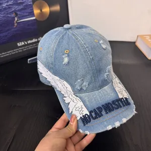 Trendy light blue denim baseball cap featuring unique wing embroidery and custom street style.