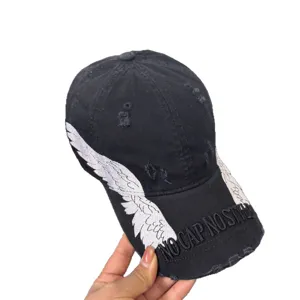 Black distressed baseball cap with embroidered wings and text for street fashion and sun protection.