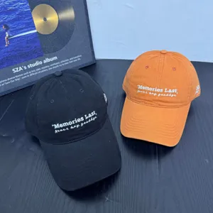 Detailed view of casual embroidered baseball caps in black and orange colors, soft top style.