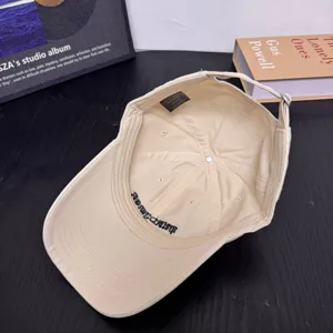 Vista detallada de gorra de béisbol de algodón beige ajustable con bordado interior y etiqueta.