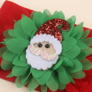 Christmas baby headband detail shot featuring green chiffon flower petals and cute Santa Claus.