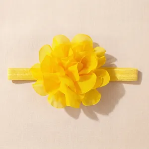Gedetailleerde close-up van gele chiffon bloem baby haarband textuur, zacht elastisch ontwerp.
