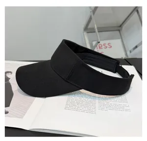 Primer plano detalle de visera solar negra de algodón, diseño liso simple para protección.