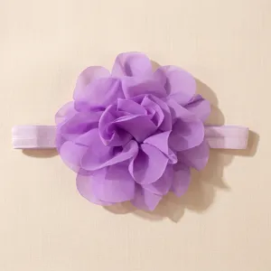 Close-up van de prachtige paarse chiffon bloem baby haarband details met zachte stoffen.