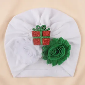 White baby turban hat featuring a sparkling Christmas gift box and cute double fabric flowers.