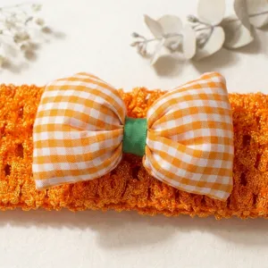 Orange knitted baby headband featuring a cute plaid bow and green ribbon detail for daily wear.