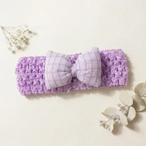 Close-up detail of the purple knitted baby headband featuring a cute plaid bow, soft.